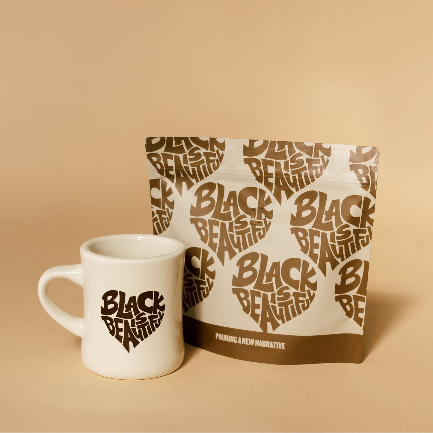 White mug and 'Black is Beautiful' branded package on a beige background